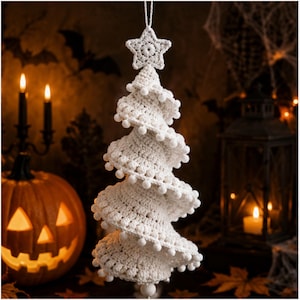 Puede incluir: Un adorno de árbol de Navidad en espiral hecho de ganchillo blanco, con una estrella en la punta y pequeños pompones en los bordes. El árbol presenta un patrón de hilo texturizado y cuelga de un cordel blanco, con un diseño cónico y en capas.