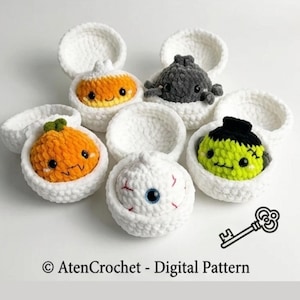Puede incluir: Cinco pequeñas figuras de peluche tejidas a ganchillo en cuencos de hilo blanco. Las figuras incluyen un caramelo de maíz, una criatura gris oscuro, una calabaza naranja, un globo ocular blanco con venas rojas y un monstruo verde. Texto: © AtenCrochet - Digital Pattern.