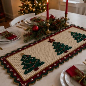 Puede incluir: Un camino de mesa rectangular de ganchillo con un centro color crema y tres aplicaciones de árboles de Navidad verdes, cada uno coronado con una estrella dorada. Tiene un borde ancho de color rojo oscuro con festones y cascabeles plateados.
