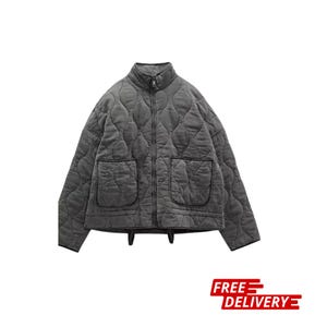 May include: A gray quilted jacket with a high collar and a full-length zipper. The jacket has two front pockets and a quilted pattern. The jacket is a neutral color and suitable for various outfits.