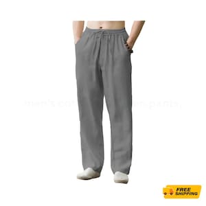 Puede incluir: Pantalones de algodón grises con cintura con cordón y bolsillos. Los pantalones son de color liso y parecen estar hechos de una tela ligera. Los pantalones son mostrados en una persona.