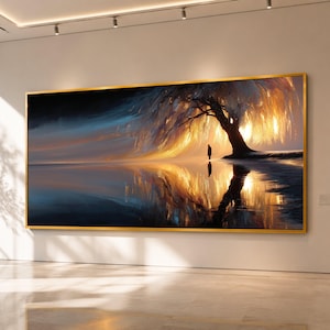 Op de afbeelding: Een rechthoekig wandkunstwerk in een gouden lijst met een landschapsschilderij van een grote, gloeiende boom met goudkleurig gebladerte. Een eenzame figuur staat onder de boom, die wordt weerspiegeld in een donker, kalm wateroppervlak onder een blauwe lucht.