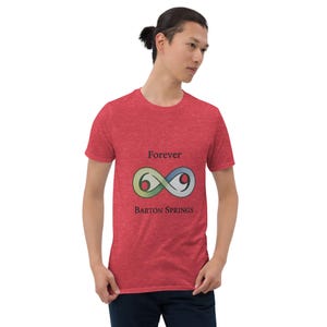 May include: Red t-shirt with the text "Forever Barton Springs" above a stylized infinity symbol in green, blue, and yellow. The shirt is made of a soft material and has short sleeves.