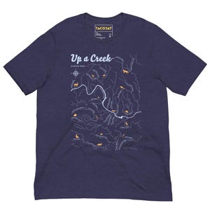 May include: Navy blue t-shirt with the text "Up a Creek" and a map design. The map features a creek and animal illustrations in a light orange colour. The shirt also has the text "In Austin, Texas".