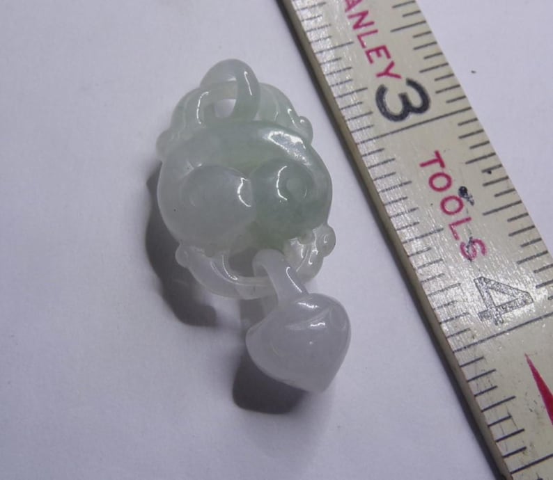 Peut inclure: Un pendentif en jade vert clair sculpt&eacute; en forme de n&oelig;ud avec un pendentif en forme de c&oelig;ur suspendu.