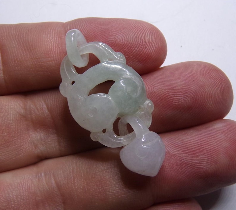 Peut inclure: Un pendentif en jade vert p&acirc;le sculpt&eacute; en forme de dragon stylis&eacute; avec un pendentif en forme de c&oelig;ur en bas.