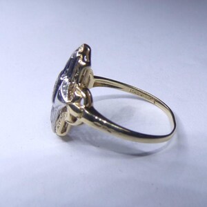 May include: A gold and silver ring with a floral design. The ring is set with small diamonds.