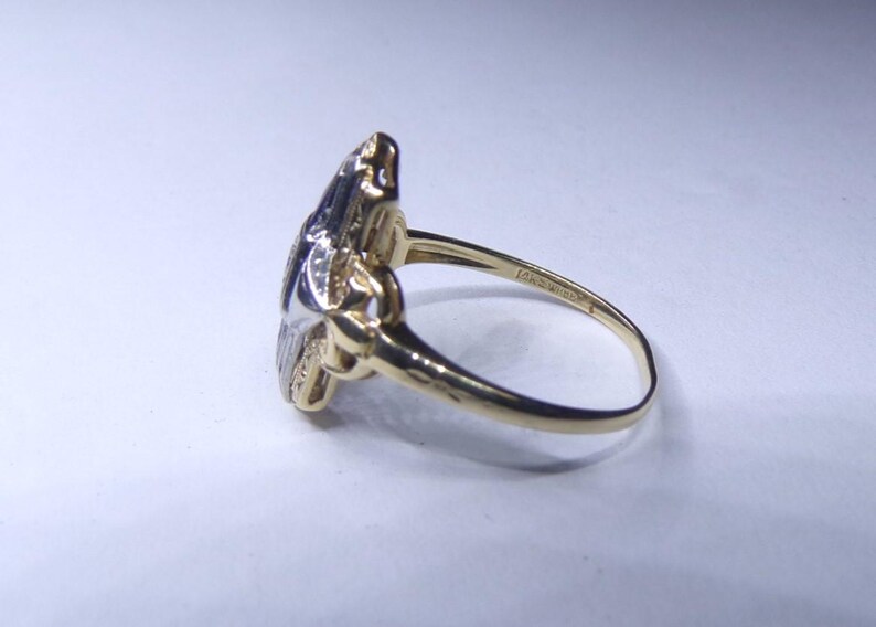 May include: A gold and silver ring with a floral design. The ring is set with small diamonds.
