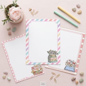 May include: Three sheets of stationery with decorative borders and illustrations of stacked books with flowers. One sheet features a diagonal pastel stripe border, another has a pink gingham border, and the third has pink vertical stripes.