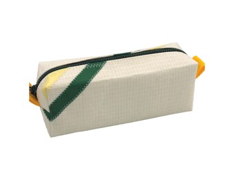 Può includere: Un astuccio rettangolare in materiale bianco sporco con motivo a griglia. Presenta una striscia diagonale verde scuro con cuciture a zigzag, una chiusura a zip verde scuro e linguette in tessuto giallo brillante alle due estremità.