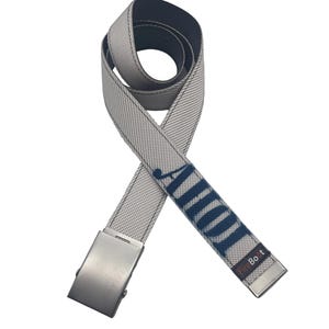 May include: A light gray webbed belt featuring a metallic silver buckle and a matching silver tip. The belt displays the dark blue embroidered name "AUDI" and a small rectangular patch with the text "FireBoot" near the end of the strap.