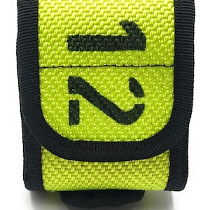 May include: A small, square, lime green pouch with black trim and a flap closure. The numbers "1" and "2" are printed in bold black font on the front of the pouch. The pouch is made of a woven fabric.