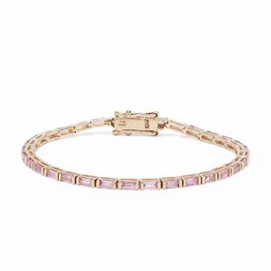 May include: A gold-toned bracelet with rectangular pink gemstones. The bracelet features a secure clasp and is designed for everyday wear. The gemstones are evenly spaced along the length of the bracelet.