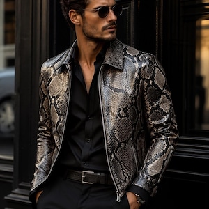 May include: A snakeskin-patterned jacket with a zipper closure, worn over a black button-down shirt and black pants. The jacket features a mix of gray, brown, and black tones. A black belt and sunglasses complete the look.