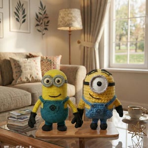 May include: Two crocheted figures resembling yellow characters with blue overalls, black gloves, and black shoes. One figure has two eyes with gray frames, and the other has one eye with a gray frame. The text PDF PATTERN and English Pattern appear.