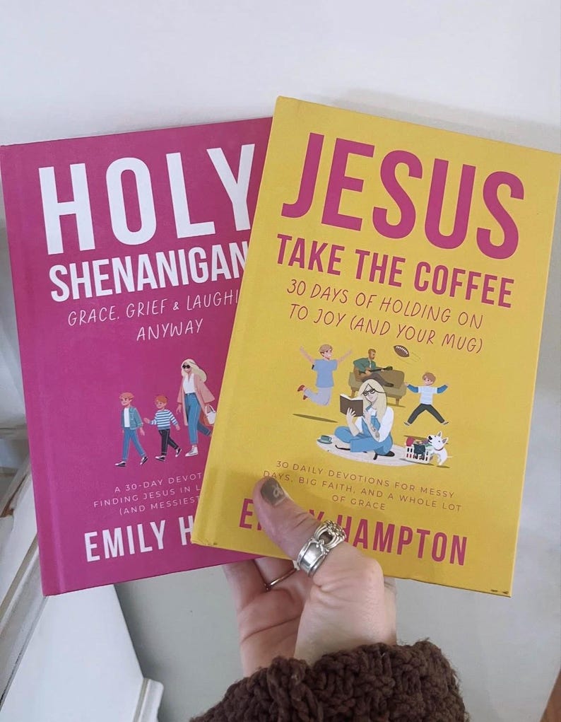 May include: Two books with colorful covers. One is pink with the title "HOLY SHENANIGAN" and the other is yellow with the title "JESUS TAKE THE COFFEE". Both books have illustrations and text. The books are held by a person.