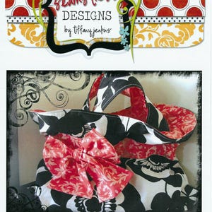 May include: A fabric tote bag featuring a black and white floral pattern with a coral pink interior and a large coral pink bow on the front. The image includes the text Tiny Seamstress Designs by Tiffany Jenkins and Jumbo Glam Bag.