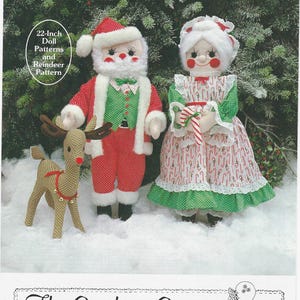Pode incluir: Um padrão para bonecos de 56 cm do Pai Natal, da Mãe Natal e da rena Rodolfo. Os bonecos estão vestidos com trajes festivos. O Pai Natal usa um fato vermelho com acabamentos brancos e um colete verde. A Mãe Natal tem um vestido vermelho e branco com detalhes verdes. Inclui também uma rena.