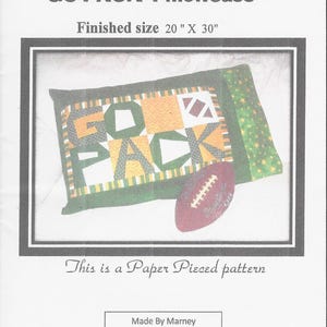 Puede incluir: Un patrón de papel para una funda de almohada "GO PACK". El tamaño final es de 50.8 cm x 76.2 cm. El diseño presenta las palabras "GO PACK" en verde, dorado y blanco, con un gráfico de fútbol americano. El patrón es de Marney.