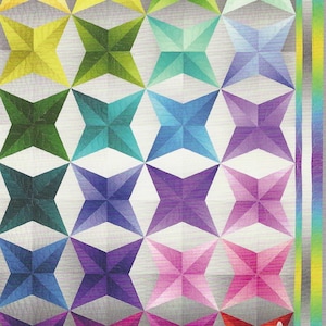 May include: A quilt pattern titled Gradient Glow featuring a grid of four-pointed star shapes in a rainbow colour spectrum against a light grey background. The border is a rainbow gradient, and the text reads Gradient Glow and Uses the Twelve Inch Squedge 45 & 22.5 Set.
