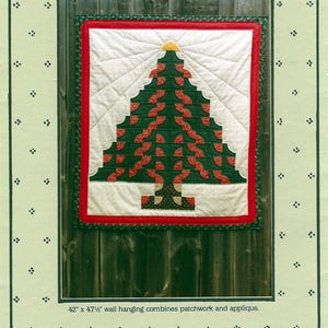 May include: A wall hanging titled "Spirited Tree" featuring a patchwork and applique design of a Christmas tree. The tree is green with red accents and a yellow star. The wall hanging measures 42" x 47.5".
