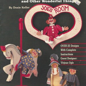 Può includere: Copertina del libro "STRING-A-LONGS" con sagome di legno di un clown, un cavallo a dondolo e altre figure. La copertina include il testo "JOE'S ROOM" e "OVER 25 Designs". Le figure sono dipinte con colori vivaci.