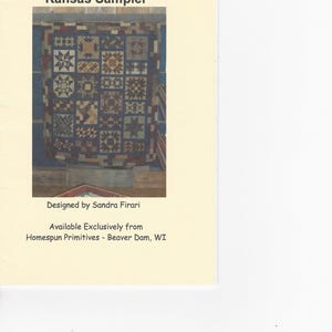 May include: A printed pattern document titled Kansas Sampler featuring a photograph of a multi-colored patchwork quilt with various geometric block designs. The text includes Designed by Sandra Firari and Available Exclusively from Homespun Primitives - Beaver Dam, WI.