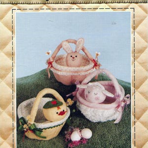 May include: A craft pattern titled "Bunny Basket & Friends" showing three stuffed animal baskets: a bunny, a duck, and a lamb. The baskets are pink, yellow, and white, with lace and ribbon details. The pattern includes instructions for Easter and nursery decor.