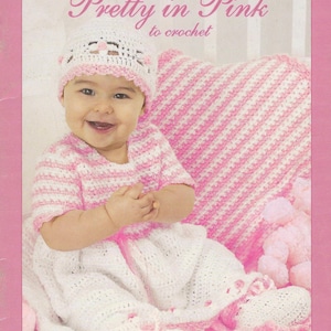 Puede incluir: Un bebé con un conjunto de crochet blanco y rosa, que incluye un gorro, una parte superior y pantalones. La imagen es de un libro de patrones de crochet "Pretty in Pink", con el texto "Baby Coordinates" en la parte inferior.