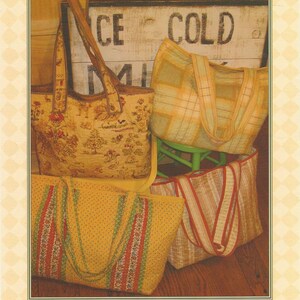 May include: A pattern cover titled Easiest Tote Bag Ever #114 by Fig Tree Quilts featuring three quilted tote bags. One bag has a floral print, one has a yellow plaid pattern, and one has a yellow polka dot design with red and green striped accents.