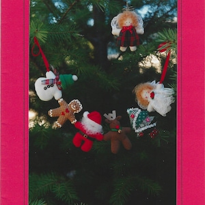 May include: A pattern booklet titled Kitty Lou's Creations Teeny Tiny Christmas Friends #3. The cover features six small fabric ornaments: an angel, snowman, gingerbread man, Santa, reindeer, and Christmas tree, each measuring 2.5 inches tall.
