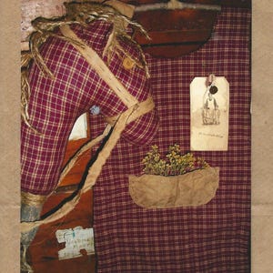 May include: A hobby horse made of maroon and white plaid fabric with a jute mane and bridle, attached to a wooden stick. It is positioned against a matching plaid fabric backdrop featuring a tan pocket filled with dried yellow flowers and a tag.
