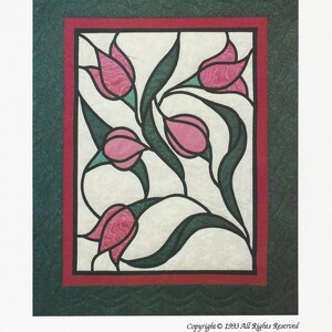 May include: A framed artwork featuring a stylized floral design of pink tulips with green leaves and stems. The artwork is set against a cream-colored background, framed by a red border and a textured green outer border. The word 'Tulips' is at the top.