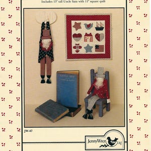 May include: A craft pattern titled "'til You Come Home" featuring a 33 cm Uncle Sam doll and a 28 cm square quilt. The image includes a doll, a quilt with patriotic motifs, and two books.
