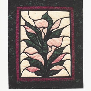 May include: A quilted wall hanging featuring a stylized floral design of calla lilies. The artwork showcases pink and cream-colored lilies with green leaves, framed by a burgundy border and a dark green background. The text "Calla Lillies" is at the top.