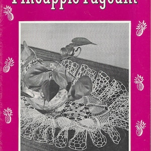 Op de afbeelding: Vintage boekcover getiteld "Pineapple Pageant" in roze met een zwart-wit afbeelding van een plant en een doily. De cover bevat de tekst "Featuring Ruffled Doilies" en ananas illustraties.