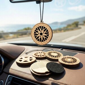 Könnte beinhalten: Luftbefeuchter für Autos aus Holz in Form von Autorädern. Der Hauptluftbefeuchter hängt am Rückspiegel. Mehrere andere Holzräder und ein schwarzes Filzpad liegen auf dem Armaturenbrett. Der Innenraum des Autos ist braun.