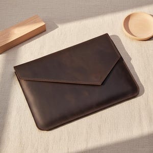 May include: A set of three ceramic mugs with a speckled, matte finish. The mugs are in shades of cream, light gray, and dark gray. Each mug has a simple, minimalist design, perfect for coffee or tea.