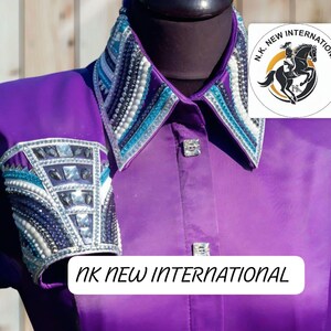 May include: A purple equestrian shirt with a decorative collar and cuffs. The collar and cuffs are embellished with silver, white, and turquoise accents. The shirt features square silver buttons and the text "NK NEW INTERNATIONAL".