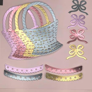 May include: A collection of colorful metal die cuts, including five woven basket shapes in pastel shades of pink, yellow, and blue. Also, there are four bow shapes and four decorative scalloped edge pieces in various colors.