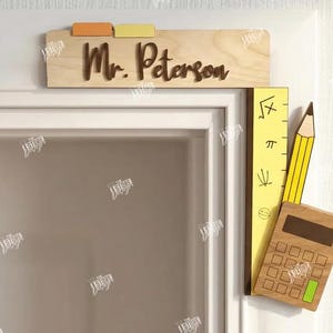Op de afbeelding: Houten deurbord voor een leraar met de naam "Mr. Peterson" in bruine letters. Het bord heeft drie gekleurde tabbladen. Een gele liniaal, een potlood en een rekenmachine zijn aan het deurkozijn bevestigd.