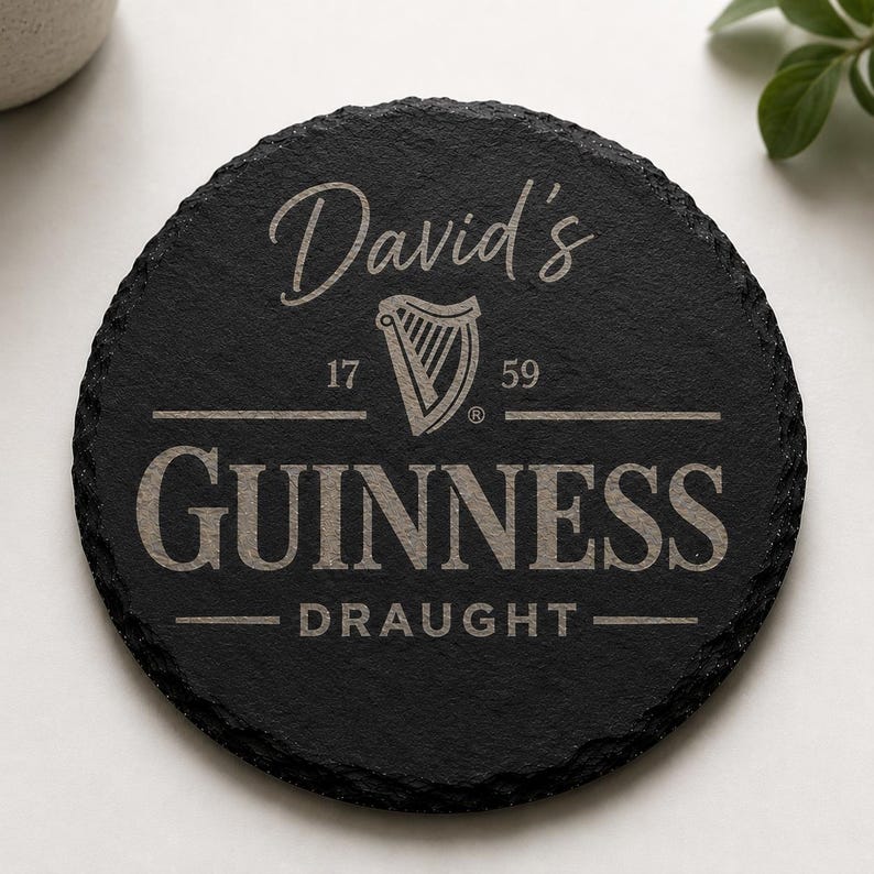 May include: A round, black slate coaster with the name "David's" in cursive script. Below, the Guinness logo is displayed with the text "GUINNESS DRAUGHT" and the numbers "17" and "59". The coaster has a rough, natural edge.