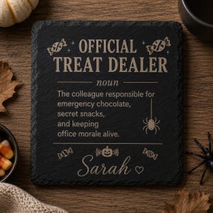 以下が含まれることがあります： 「OFFICIAL TREAT DEALER noun The colleague responsible for emergency chocolate, secret snacks, and keeping office morale alive.」と刻印された正方形の黒いスレートコースター。キャンディ、クモ、そして「Sarah」という名前がデザインされています。