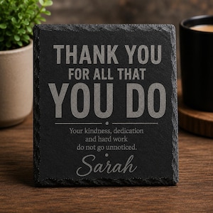 May include: A square black slate plaque with rough, textured edges. The engraved text reads: THANK YOU FOR ALL THAT YOU DO, Your kindness, dedication and hard work do not go unnoticed. Sarah. The plaque features a dark grey, matte finish.