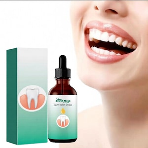 Puede incluir: Una botella de vidrio marrón con un cuentagotas negro y una etiqueta blanca que dice "South Moon Gum Relief Drops". Una caja verde y blanca con un gráfico de diente está al lado de la botella. Una persona sonríe en el fondo.