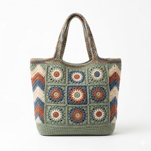 May include: A handmade crochet tote bag in shades of green, blue, cream, and rust. The bag features a floral square pattern and a chevron design on the sides. The handles and trim are a coordinating green.