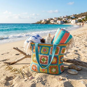 May include: A vibrant, crocheted beach bag, filled with beach items, rests on a sandy beach. The bag has a patchwork design in various colours. Inside are a rolled striped towel, a white towel, sunglasses, and a bottle of sunscreen.