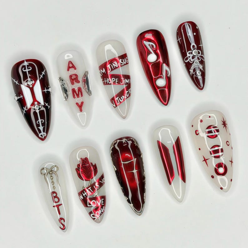 Peut inclure: Dix faux ongles aux motifs vari&eacute;s. Les ongles sont de couleurs claires, rouges et blanches. Certains ongles comportent des textes tels que "ARMY", "BTS" et des paroles de chansons. D'autres pr&eacute;sentent des notes de musique, des roses et des motifs g&eacute;om&eacute;triques.