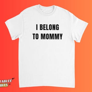 May include: White t-shirt with the text "I BELONG TO MOMMY" in bold, black capital letters. The shirt has short sleeves and a crew neck. The brand logo "RELATABLEE SHIRTS" is at the bottom left.