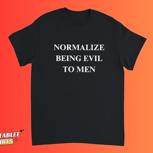 Könnte beinhalten: Schwarzes T-Shirt mit dem weißen Text "NORMALIZE BEING EVIL TO MEN". Das Shirt hat kurze Ärmel und einen Rundhalsausschnitt. Das Relatablee Shirts-Logo befindet sich unten links.